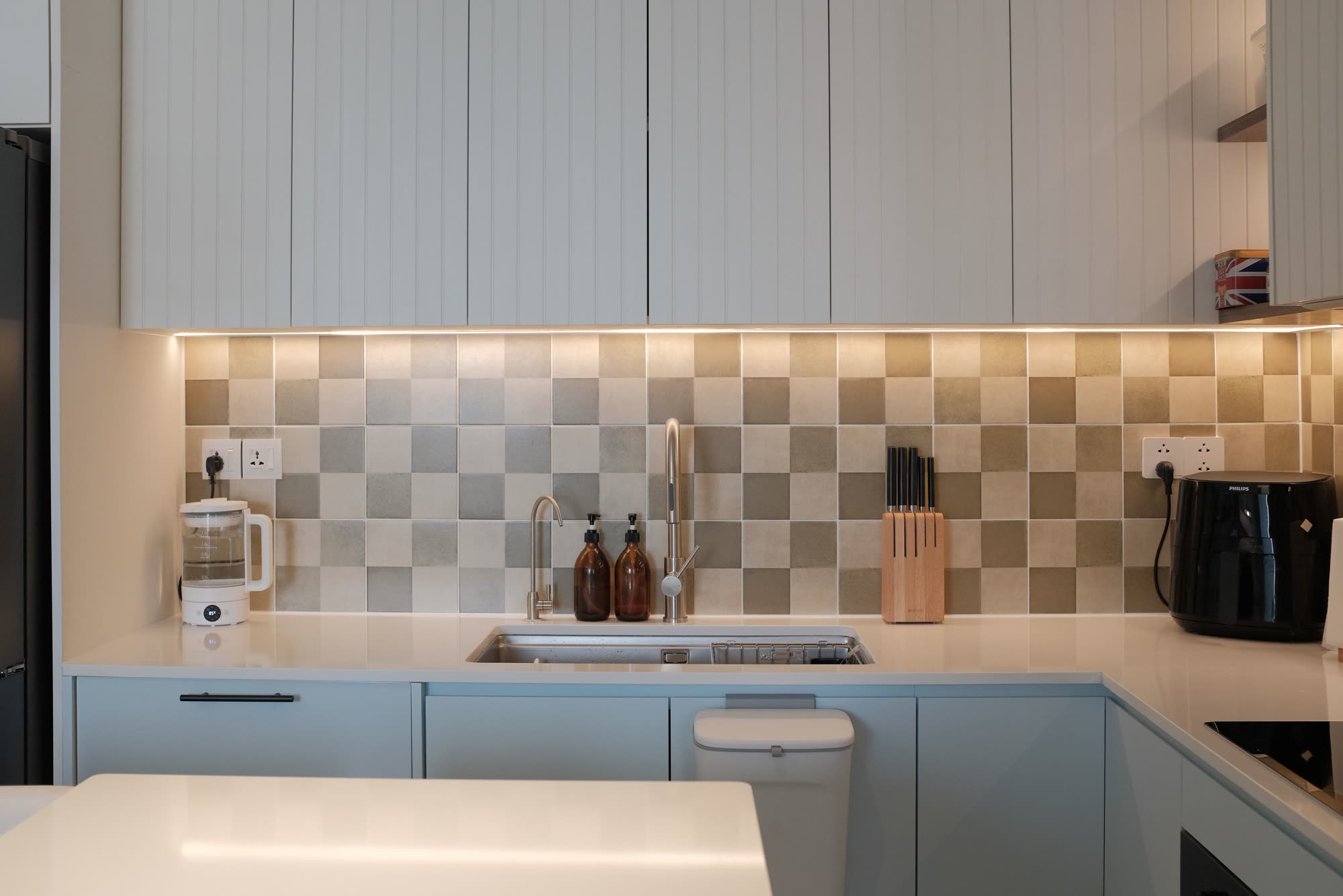 Modern kitchen renovation showing completed countertop installation with coordinated backsplash