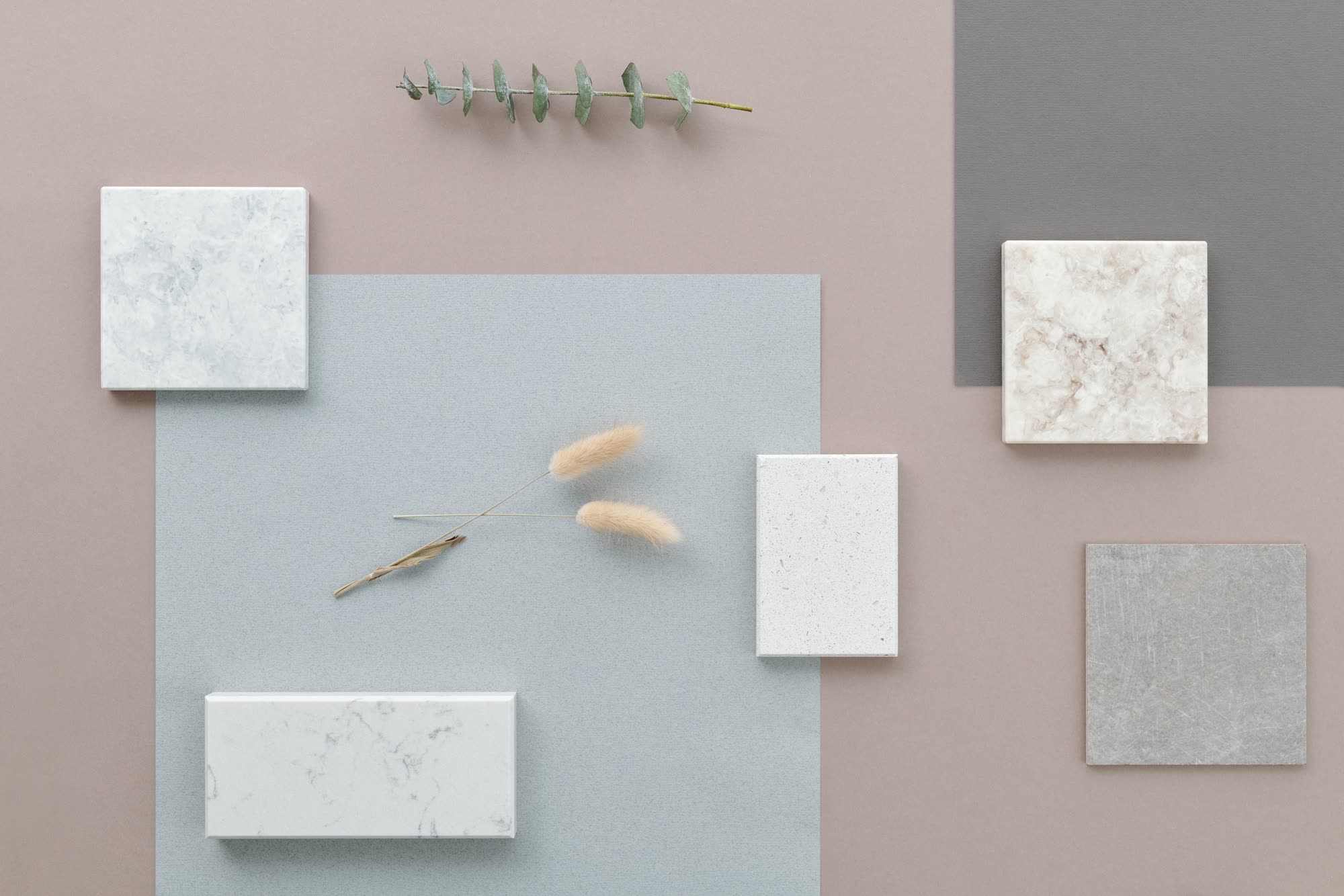 Quartz and engineered stone material samples arranged for comparison, various colors and patterns displayed